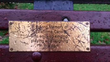 The dedication plaque on a park bench