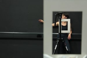 Various white frames are laid over an image of a dancer stood behind a camera