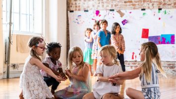 five children holding hands in a performance