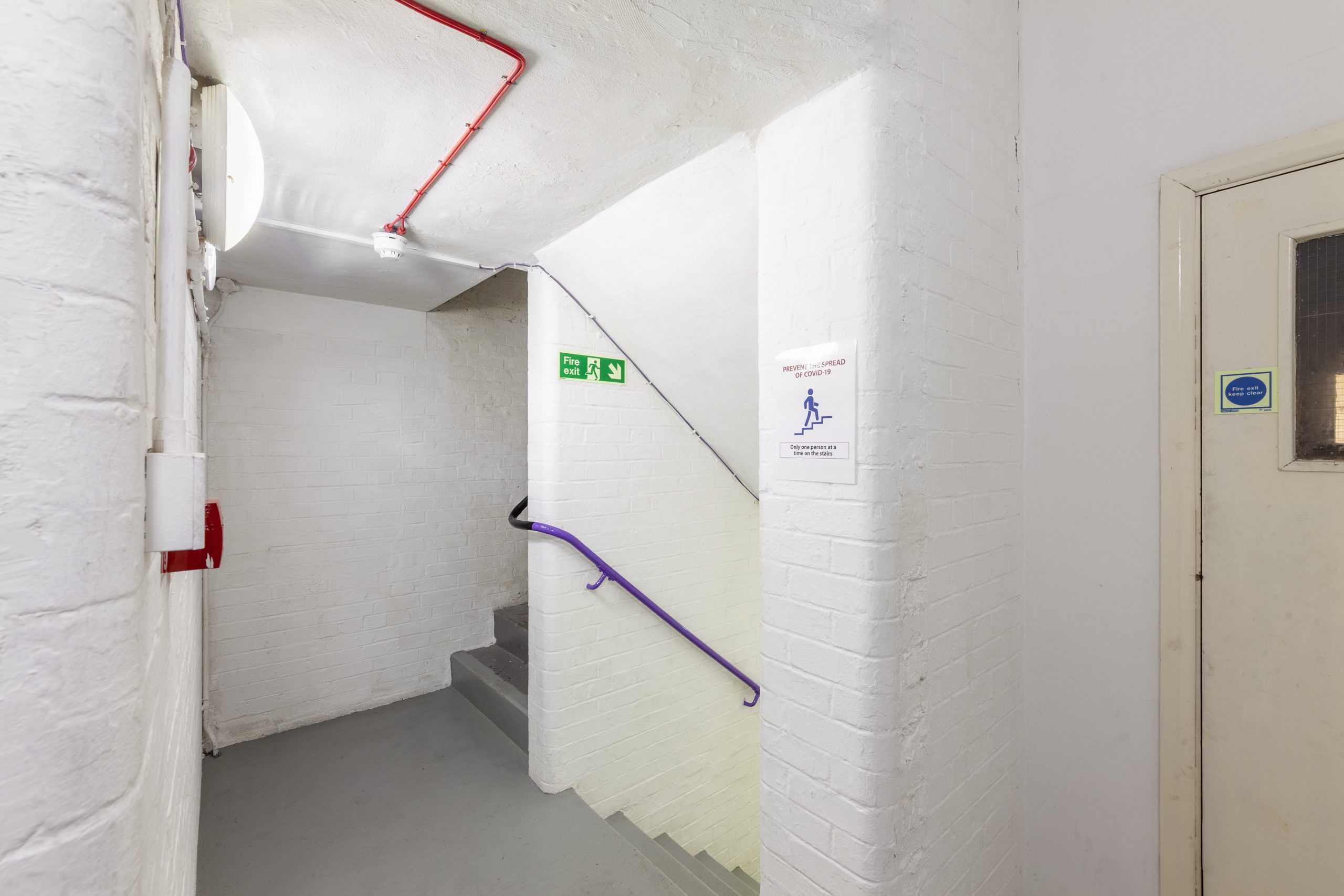 A white staircase with a purple banister